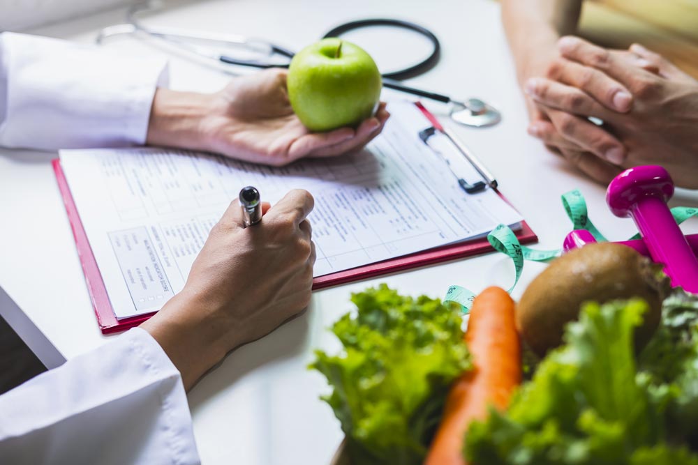 Consulta con una manzana, notas y alimentos sobre la mesa