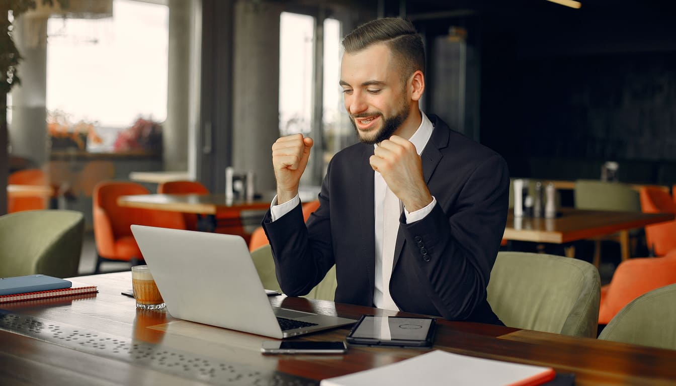 hombre de negocios feliz con portatil y cafe