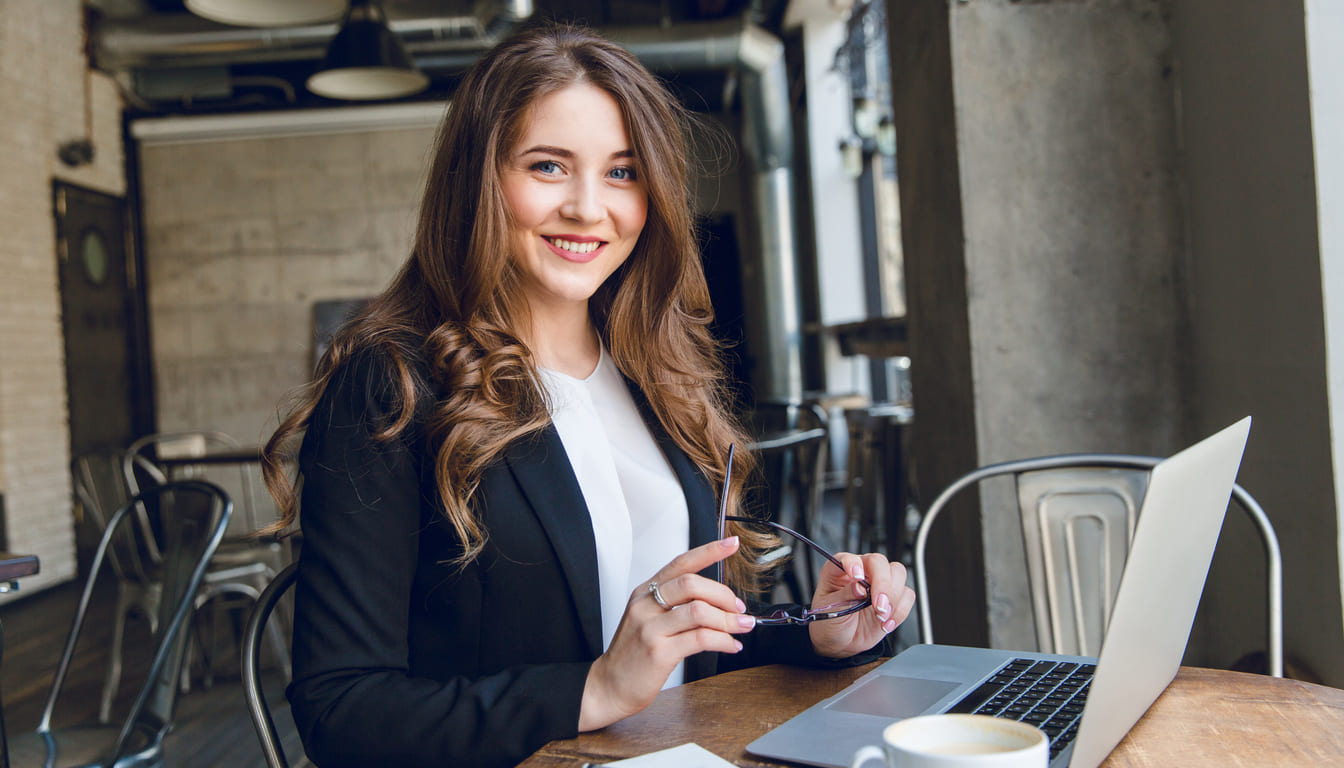 mujer de negocios sonriente con portatil y cafe